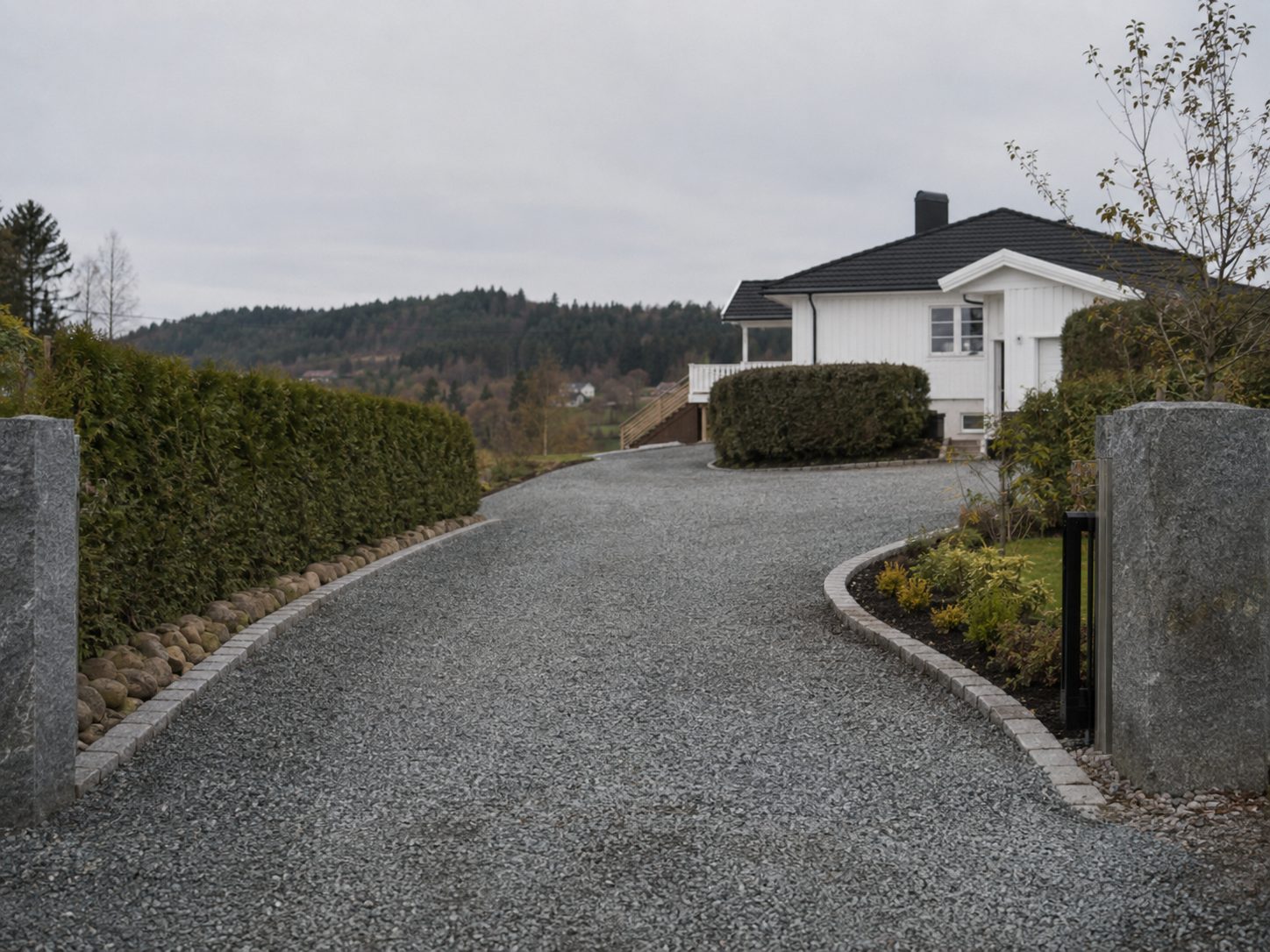 Ferdig grusoppkjørsel med granittsøyler ved enebolig i Holmestrand